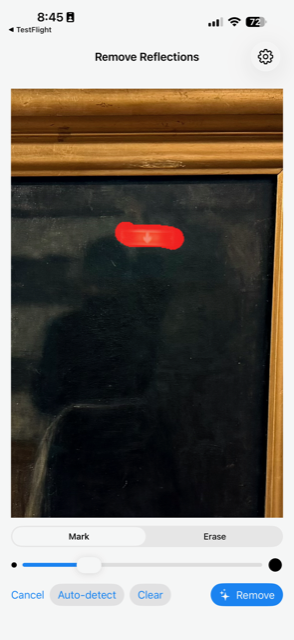 Reflection editor showing the glare highlighted with a red mask overlay and brush controls